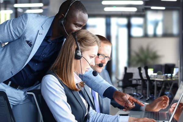 team working on a call center and collegues helping each other