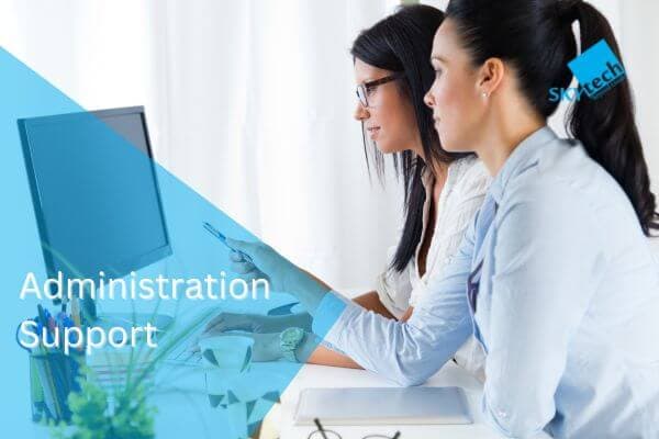 two girls sitting in font of desktop. skytech dministration support concept